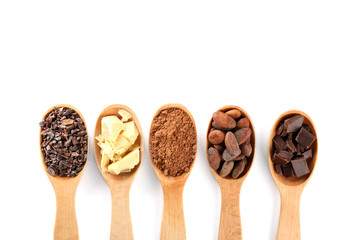 Spoons with different cocoa products on white background