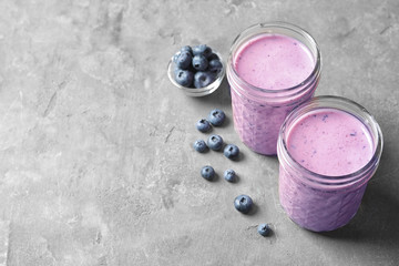 Jars with berry protein shakes on table