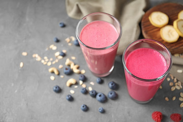 Glasses with berry protein shakes on table