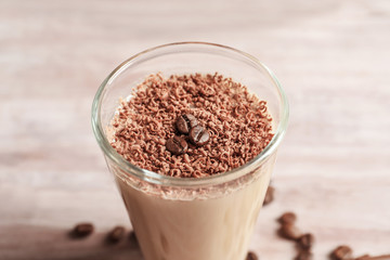 Glass with chocolate protein shake on table, closeup