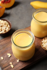 Jars with fruit protein shakes on table, closeup