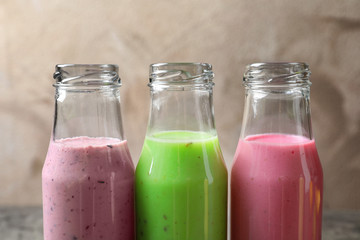 Bottles with different protein shakes on table, closeup