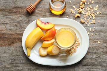 Jar with protein shake and plate with fruits on table