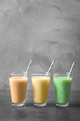 Glasses with different protein shakes on table