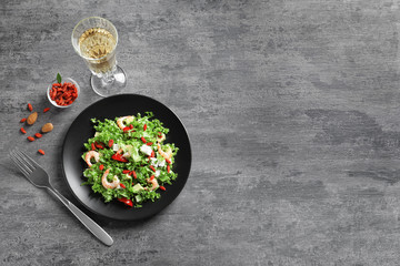 Composition with delicious goji berry salad and white wine on grey background