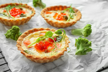 Tasty salmon tartlets on baking grid, closeup
