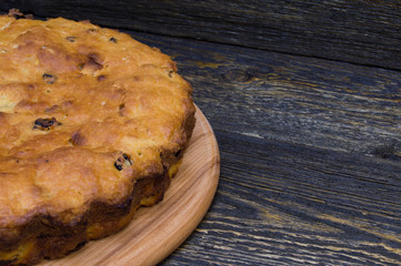 Homemade pie with raisin on grunge wooden table