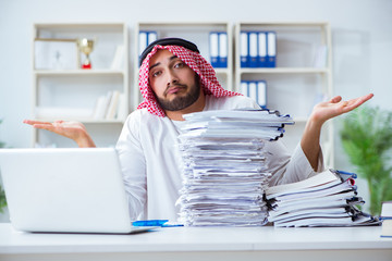 Arab businessman working in the office doing paperwork with a pi