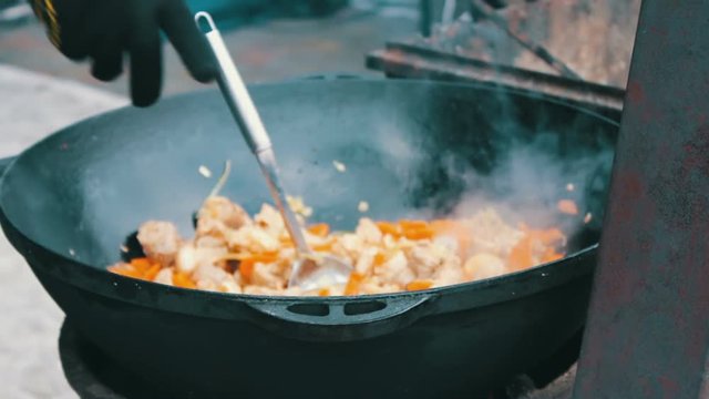 The most delicious Uzbek pilaf with carrots rice and meat is brewed in huge tub at the festival food court