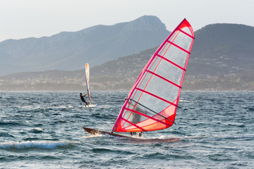 Sunset over the sea or ocean and extreme freestyle sport windsurfing