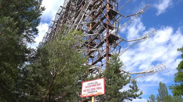 Chernobyl zone, Ukraine - 18th of June 2017: Visit to Duga radars (Soviet over-the-horizon radar system)- 4K Prohibited area sign and Duga array behind it