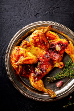 Grilled fried roast Chicken Tabaka with thyme and garlic, in Frying pan on wooden Background.Festive dish.