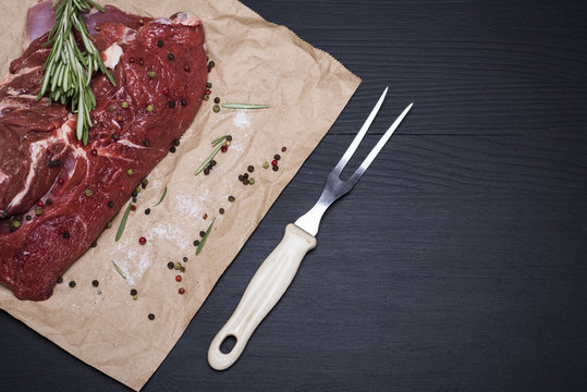  raw beef on brown sheet of paper and fork