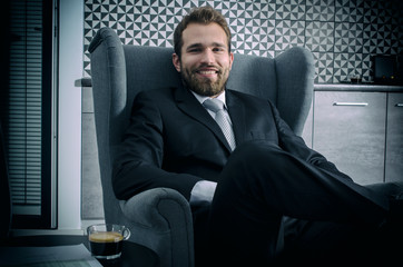 Businessman sitting on an armchair in home