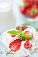 Fruit dessert of strawberries close-up with a dairy cocktail in a glass vase.