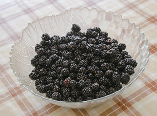 Plate with berries black blackberries. Fruits berries on the table