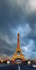 Fototapeta na wymiar Eiffel Tower on a stormy evening reflecting the last rays of setting Sun, space