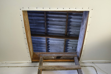 Open the entrance to the attic. The staircase and the door to the attic of the house