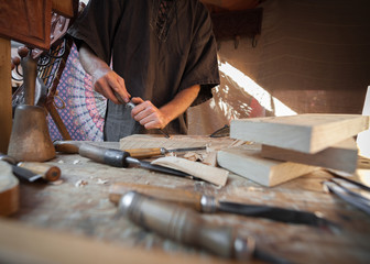 Wood craftsman with various hand tools working.