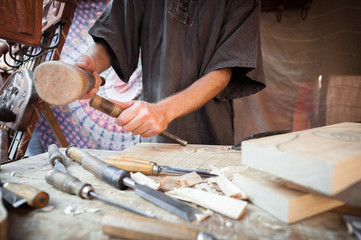 Wood craftsman with various hand tools working.