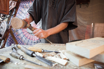 Wood craftsman with various hand tools working.