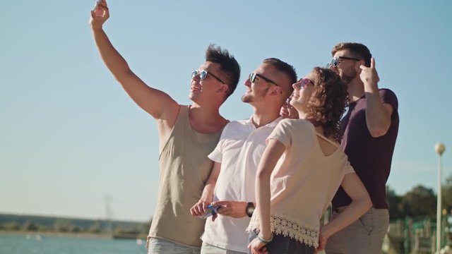 Young people making a selfie on the beach. Medium shot. Soft Focus.
