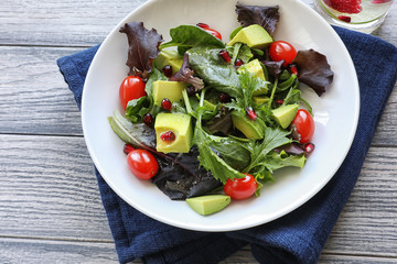 Salad with tomato baby lettuce in white bowl