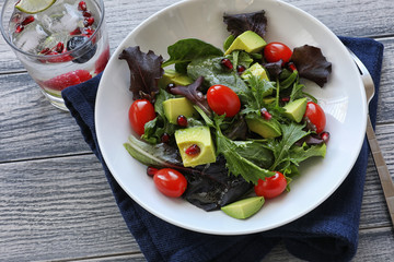 Salad with tomato baby lettuce in white bowl