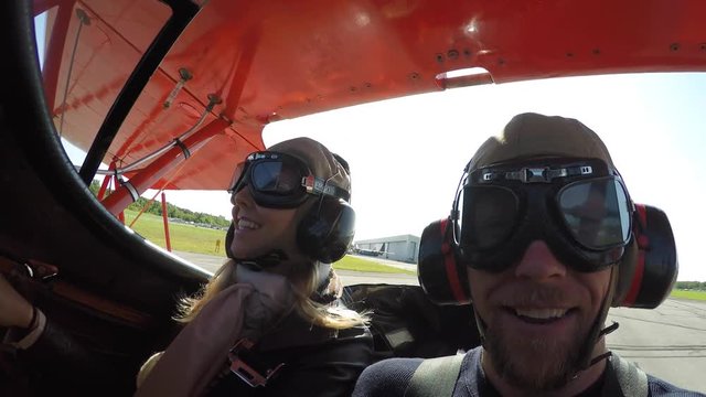 couple in biplane prepare for takeoff and wave 4k