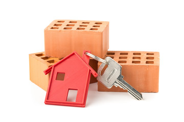 House door key with red house key chain pendant and bricks