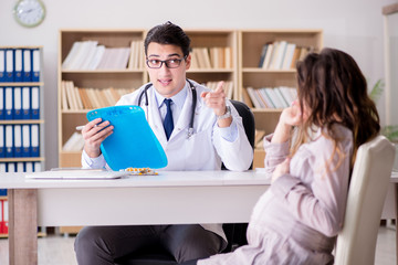 Fototapeta premium Pregnant woman visiting doctor for consultation