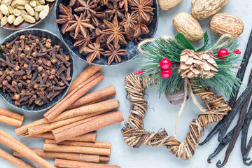 Different kinds of aromatic winter spices in bowls and on gray concrete background, top view, horizontal