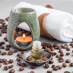 Aroma lamp with coffee essential oil on a woven mat, spa background, square format