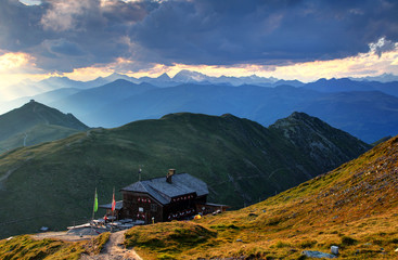 Sillian hut in Carnic Alps main ridge with Helm / Elmo and snowy Hochgall / Collalto peaks, blue...