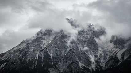 Gray rocky mountain in clouds