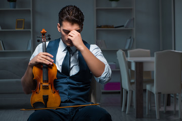 Young musician man practicing playing violin at home