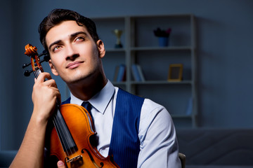 Young musician man practicing playing violin at home