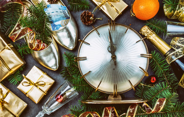 NEW YEAR CELEBRATION. Traditional put money to shoe for have money en New Year. Flat lay composition with vintage clock, shoes with chilean money pesos, champagne, Christmas decorations