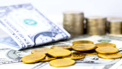 Golden coins stack and us dollar banknote on white table background.