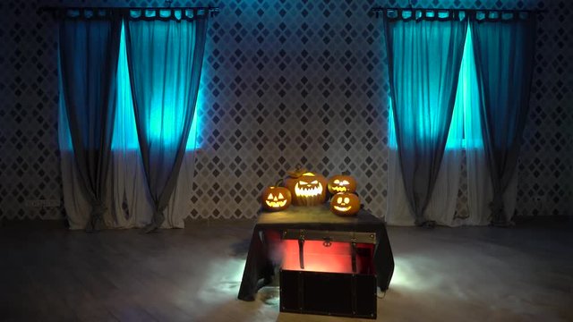 Scary zombie girl in nightie with axe is looking for victim, celebrate halloween with funny angry frightening pumpkins. Gates of hell with smoke and fire. Woman from the ring movie