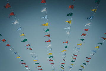 Flag banners blowing in wind. Flapping flags. Streamer flags. Abstract flag colors. Pennant flag strings. Color pennants. Abstract design art. Urban geometry.