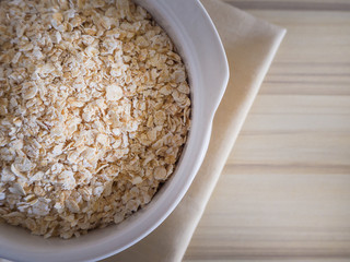 The oats rice in white bowl on top table wood worm tone image