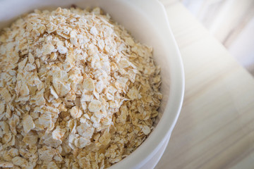 The oats rice in white bowl on top table wood worm tone image
