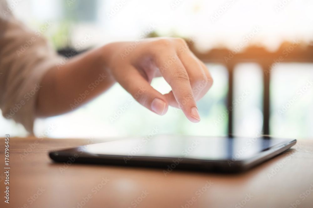 Poster close up of mans hands using tablet on counter.