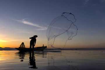 Fishermen while fishing reservoir morning ,Thailand.