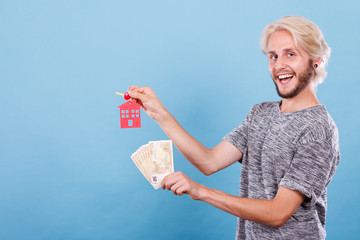 Man holding money and keys to house