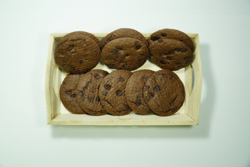 Chocolate chip cookies on a wooden tray isolated over white background