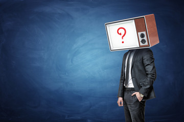 A businessman has one hand in a pocket and a head replaced by an oil TV with a question mark on the screen.