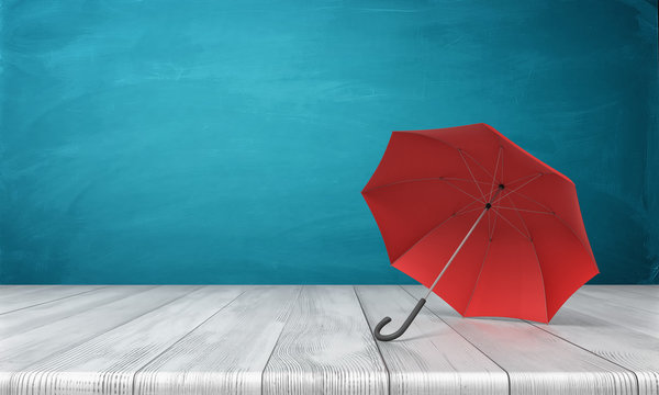 3d rendering of a single red open umbrella lying on its side with an open canopy on a wooden surface on blue background.