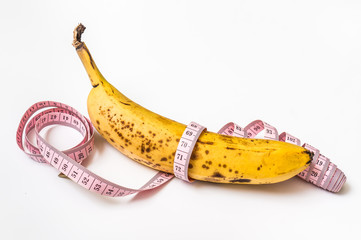 Yellow banana with measuring tape - diet concept